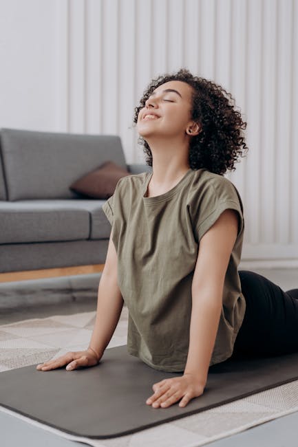 Close-up of a person performing a stretching exercise on a mat at home.